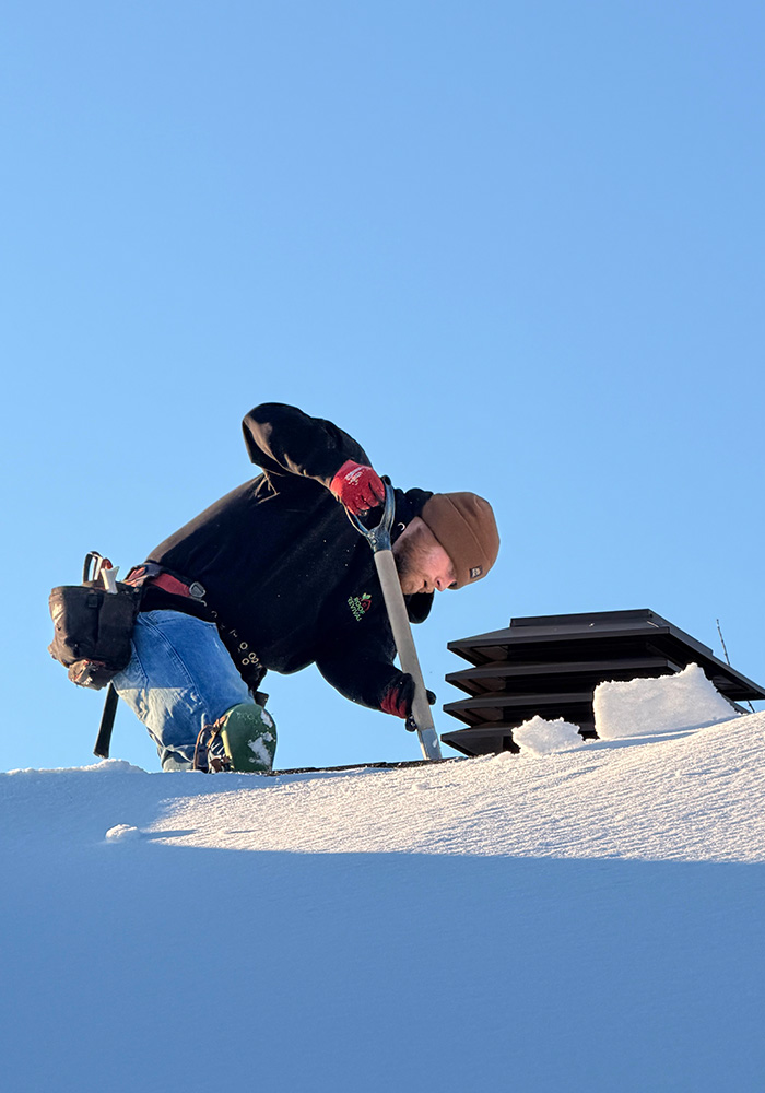 Roof technician working on snow-covered roof in Ottawa winter demonstrating durability in Canadian climate