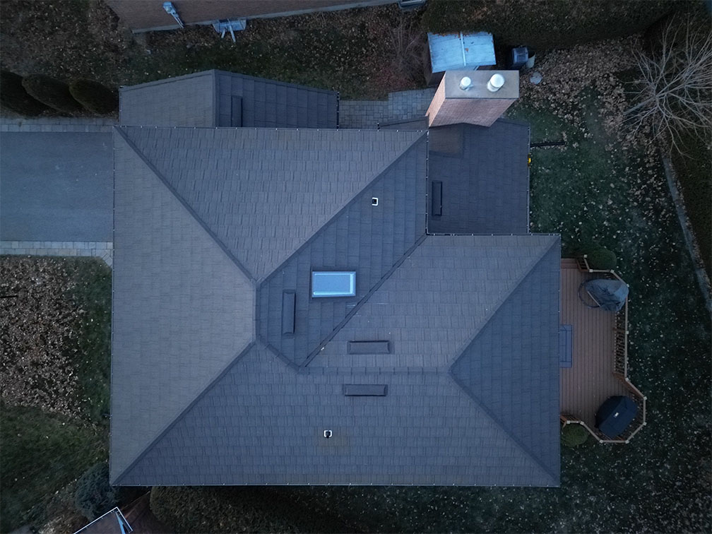 Drone view of newly installed asphalt shingle roof on residential home